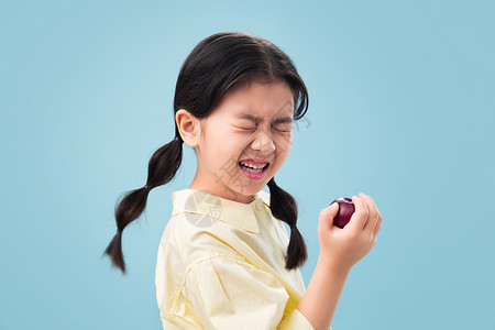 吃酸水果的小女孩高清图片