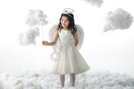 棉花云站着天使装扮的快乐小女孩图片