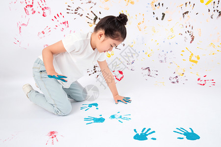 手脚印创造力油漆高兴画画的小女孩背景