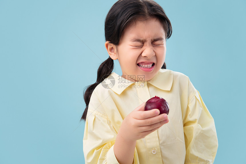 面部表情休闲装东亚吃水果的小女孩图片