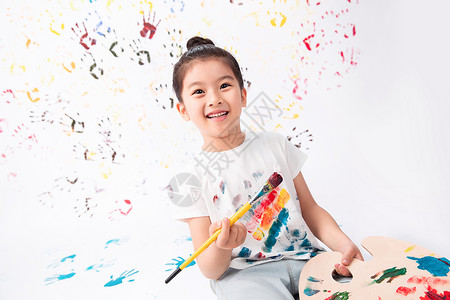 拿画笔素材表现积极多色的白昼拿画笔画画的小女孩背景