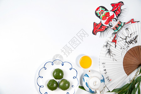 扇子茶壶和叶子青团和传统文化工艺品背景