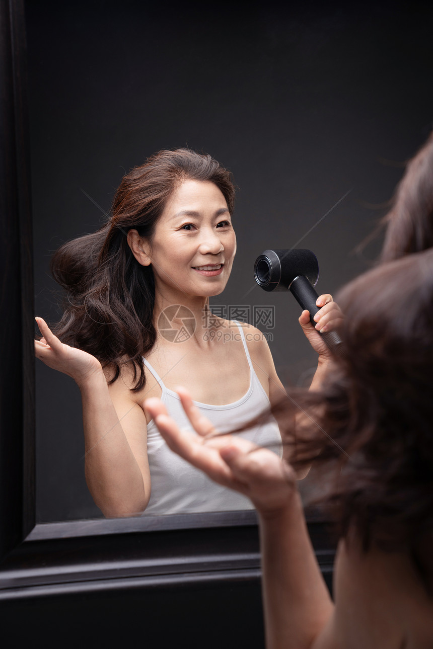 中年女人用吹风机吹头发图片