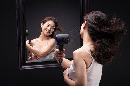 中年女性发型幸福中年女人用吹风机吹头发背景