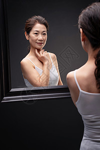 漂亮的中年女欣赏镜子中的自己图片