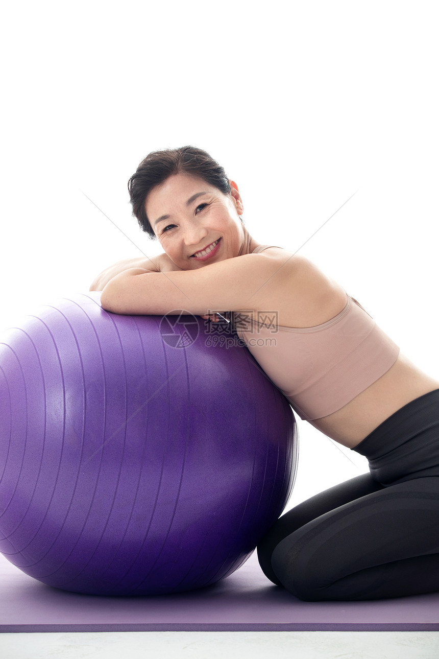 趴在瑜伽球上的中年女人图片