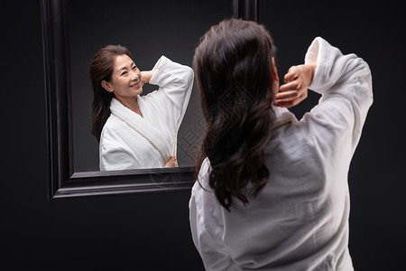 照镜子捋头发的优雅中年女人图片