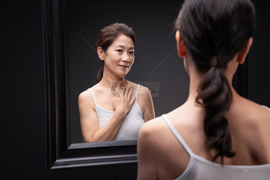 中年女人欣赏镜子中的自己图片