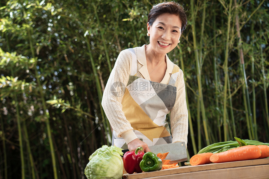 庭院内切菜的中年女人图片