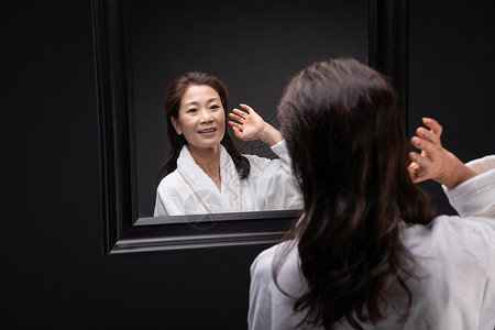 照镜子捋头发的优雅中年女人图片