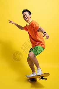橙色运动嘻哈玩滑板的青年男人背景