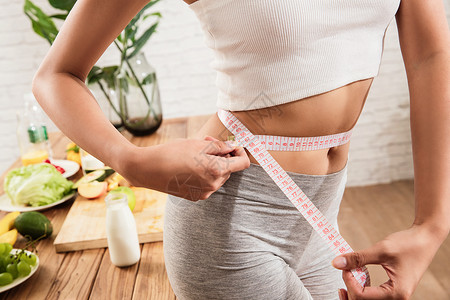 减肥季节健康女人测量腰围背景