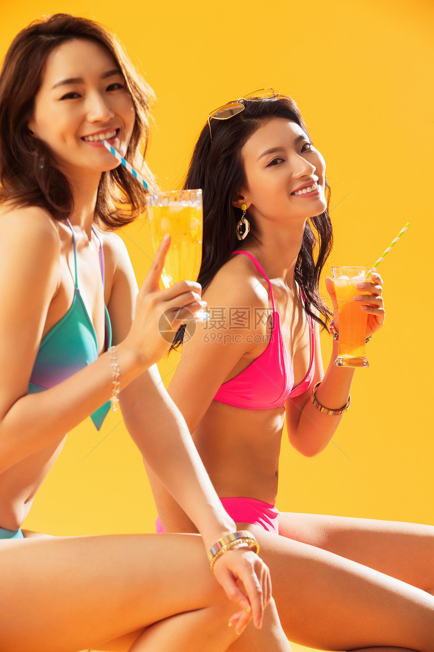 清新享乐快乐闺蜜在沙滩上喝饮料图片