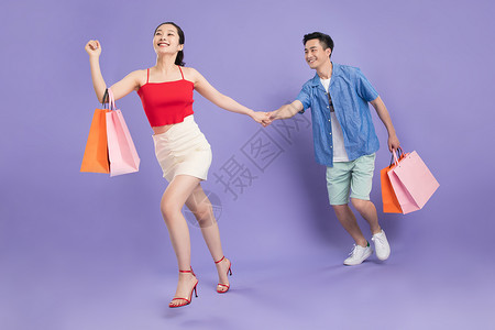 高跟鞋跑步相伴短裤购物袋快乐的青年情侣购物背景