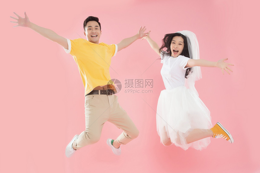 两个人女人张着嘴快乐的年轻情侣跳跃图片