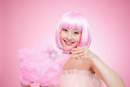 快乐粉色女拿着棉花糖的年轻女孩图片