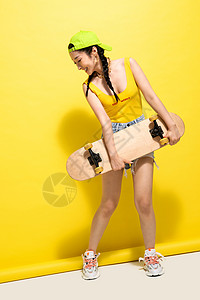 抱着滑板的年轻女孩图片
