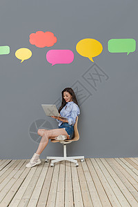 全身像坐着对话框使用笔记本电脑的青年女士图片