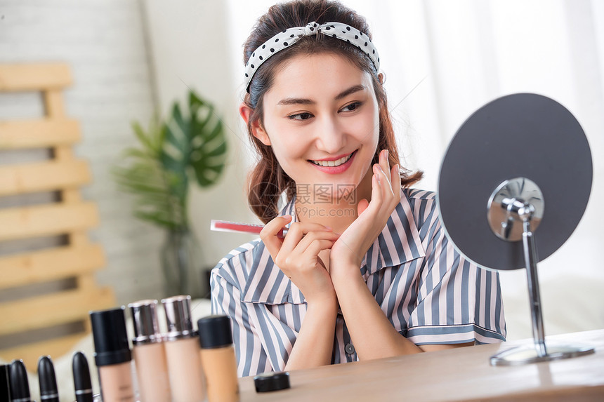 愉悦不看镜头休闲活动在化妆的青年女人图片