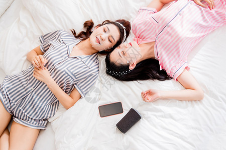 东方人时尚女人躺在床上敷面膜的年轻闺蜜图片