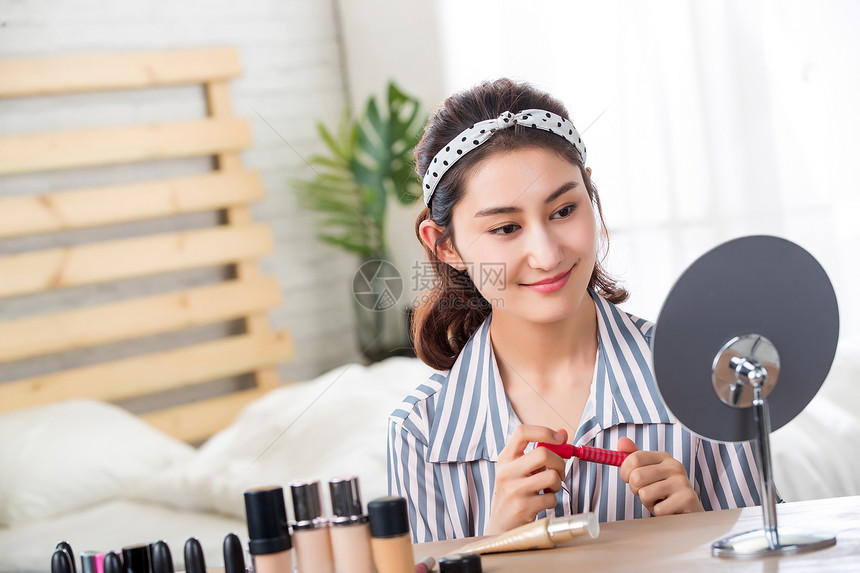 东方人睡衣户内在家化妆的青年女人图片