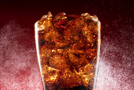 可乐倒入装满冰块的杯中高清图片