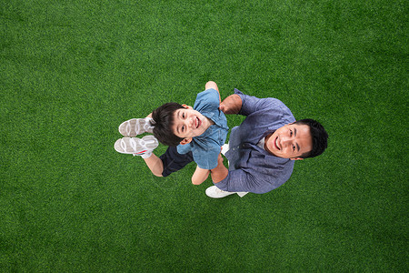 草地上快乐的父子俩背景图片