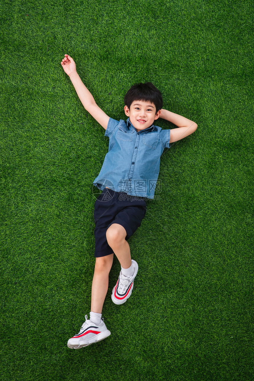 可爱的小男孩躺在草地上图片