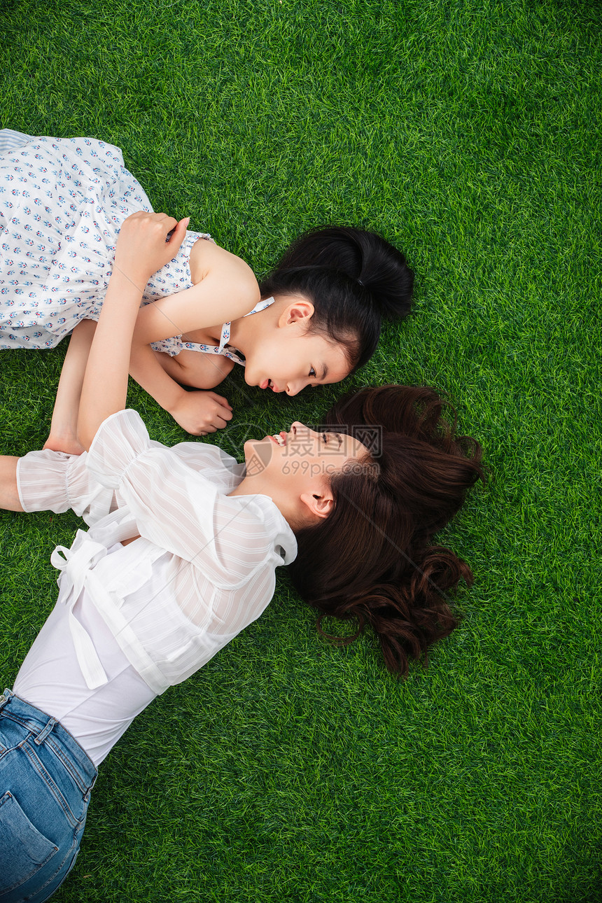 单亲家庭生态旅游乐趣幸福的母女躺在草地上玩耍图片