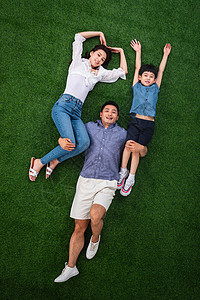 夏天温馨高举手臂在草地上青年男人驮着妻子和儿子图片