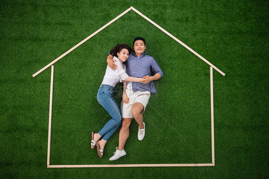 青年伴侣躺在草地上的房子轮廓里图片