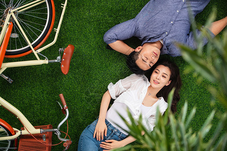 减压成年人放松甜蜜的青年伴侣躺在草地上图片