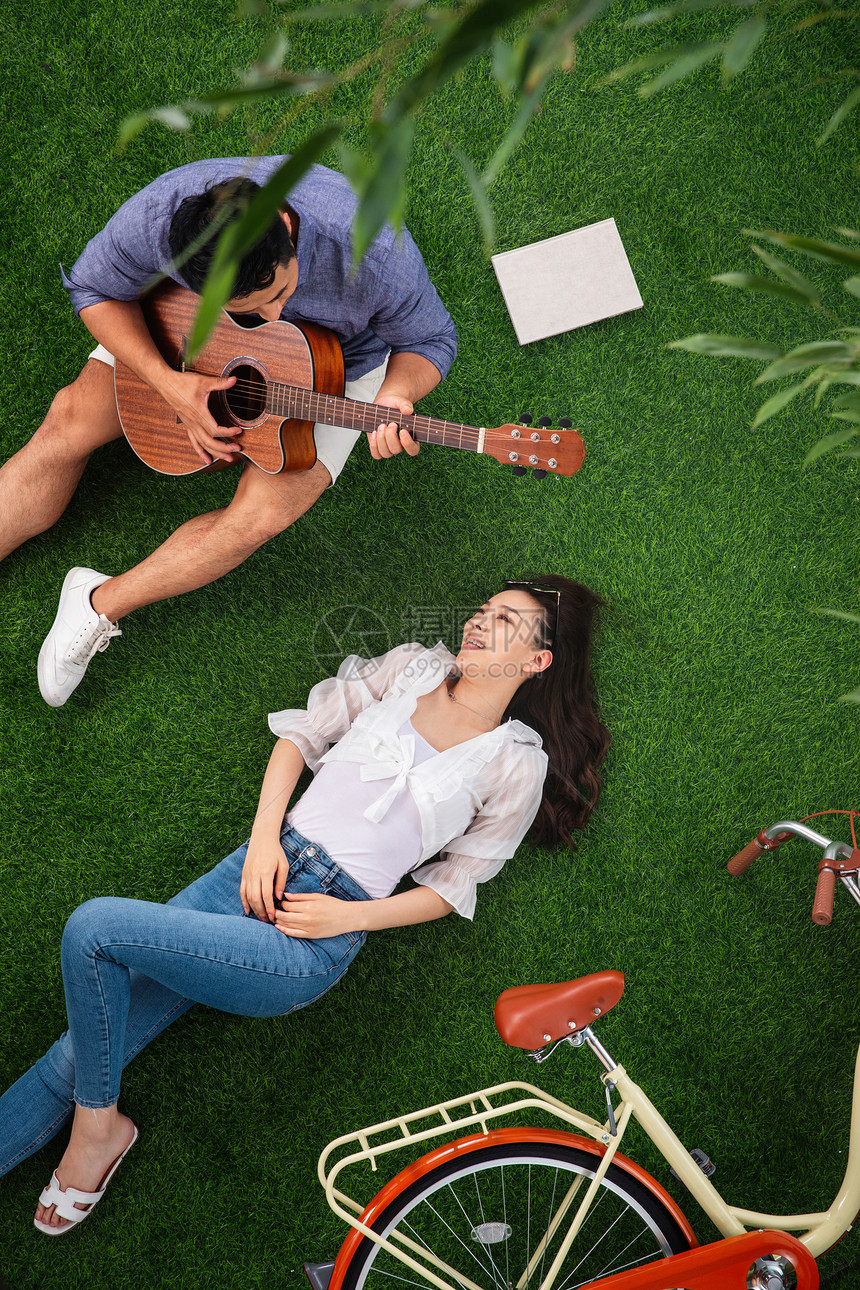 竹子东亚陪伴幸福的青年伴侣在草地上享受甜蜜时光图片
