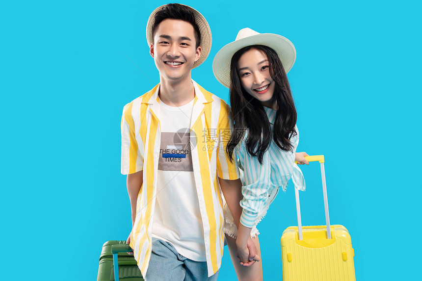 快乐的青年情侣手牵手拉着行李箱去旅游图片