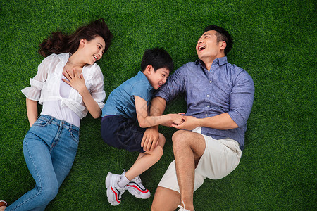 聊天表情贴纸的孩子快乐的三口之家躺在草地上嬉戏背景