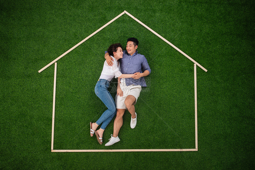 青年伴侣躺在草地上的房子轮廓里图片
