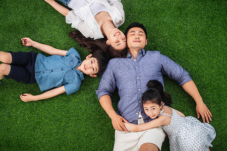 儿童关爱减压幸福的一家四口躺在草地上图片