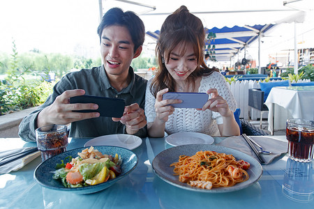 用手机拍美食的快乐情侣高清图片