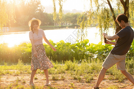湖边约会女朋友户外男朋友幸福情侣在公园里拍照背景