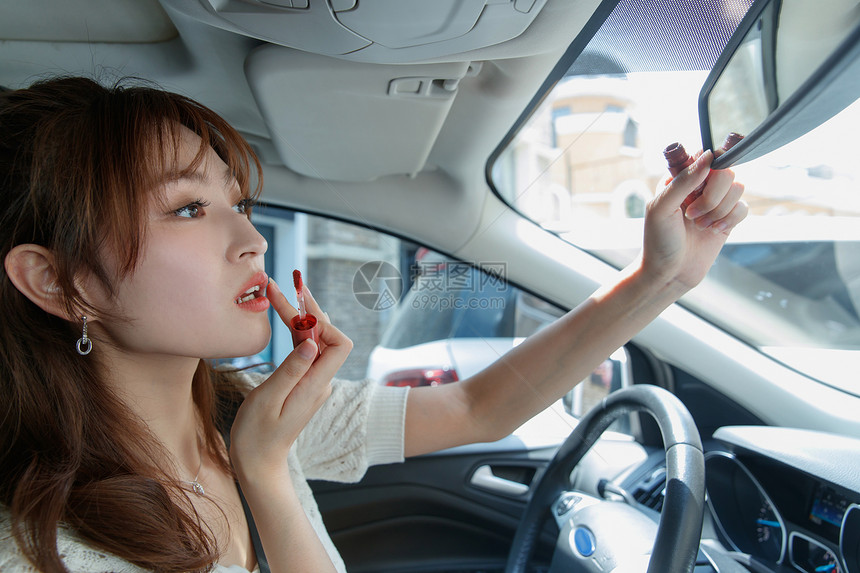 青年女人在汽车里化妆图片
