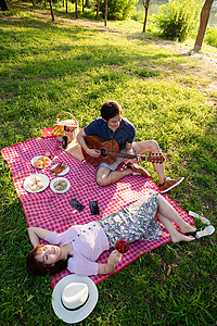 女朋友享乐摄影在公园里弹吉他的幸福情侣图片