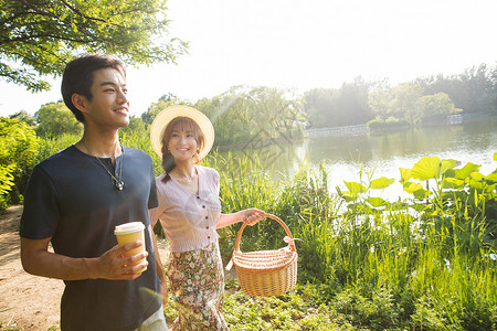 湖边约会北京步行生态旅游在公园里郊游的幸福情侣背景