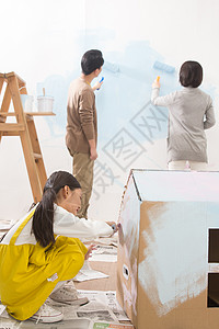 油漆和托盘刷幸福青年男人油漆快乐家庭装修房子背景