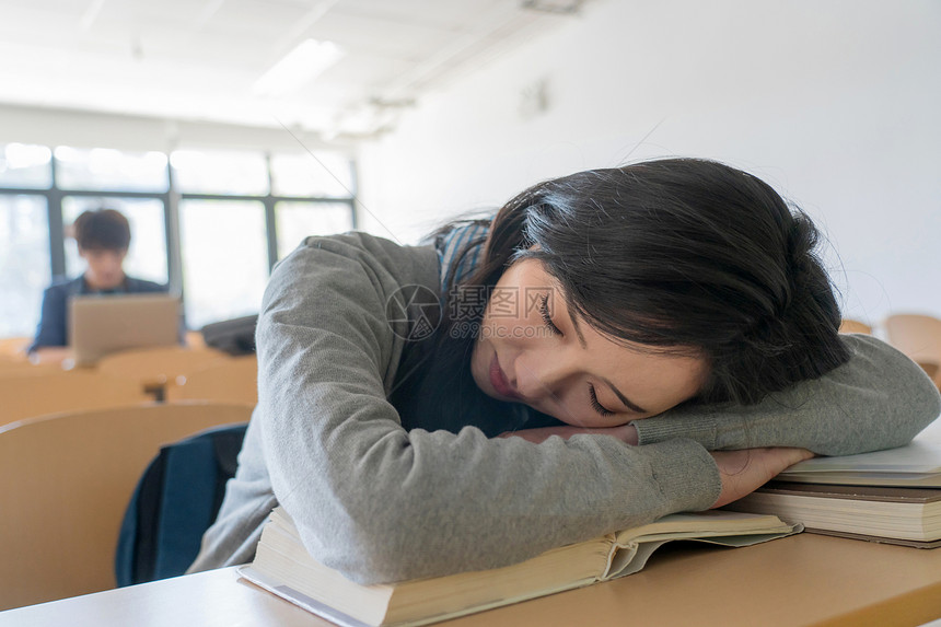 疲劳的大学生在教室里睡觉图片