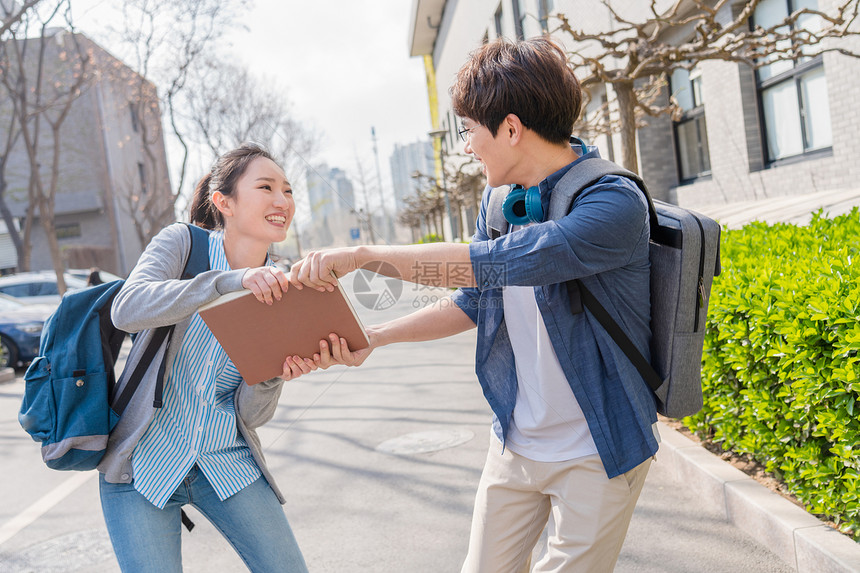 快乐活力大学生情侣在校园里散步图片