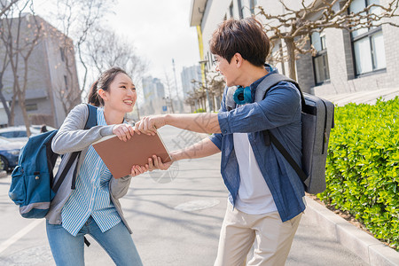 快乐活力大学生情侣在校园里散步图片