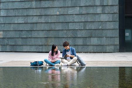 校园的池塘大学生情侣在校园里背景