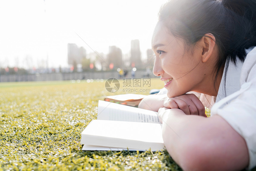 休闲装青年女大学生在校园里学习图片