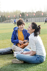 青年文化人青年大学生在校园里弹奏吉他图片
