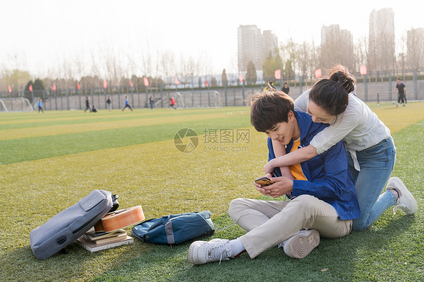 大学生情侣坐在校园里图片